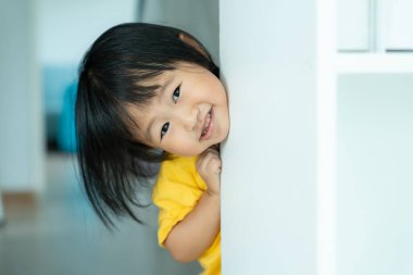 Küçük Asyalı çocuk duvar evinde saklambaç oynuyor, sevimli çocuk evde eğleniyor. Mutlu aile çocuklarla eğlenir, etkinlik, öğrenme, aktivite, oyun, meditasyon