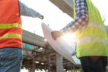 Mühendisler inşaat planlarını gözden geçirir. Sivil projeye başlamadan önce müteahhit teftişi çizimi. proje planlaması, danışmanlık, mimari