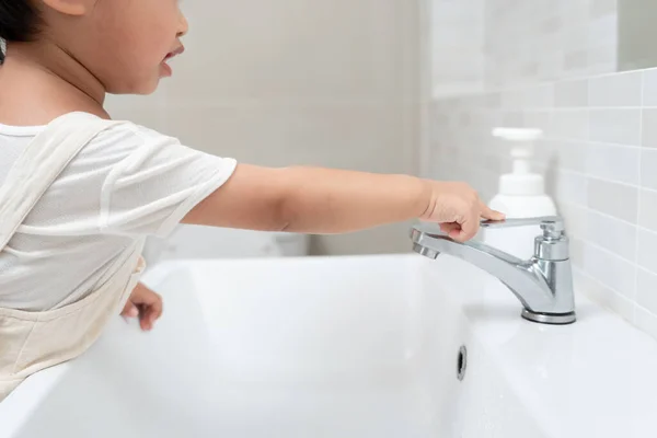 Save water. Little kid keeps turning off the running water in the bathroom to protect environment. Greening planet, reduce global warming, Save world, life, future, risk energy, crisis , water day.