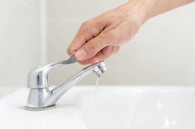 Save water. Volunteer keeps turning off the running water in the bathroom to protect environment. Greening planet, reduce global warming, Save world, life, future, risk energy, crisis , water day.