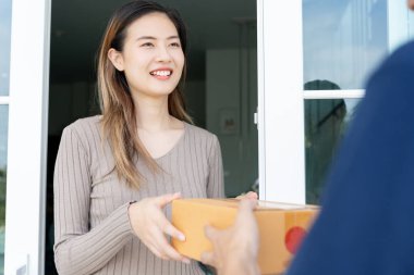 Mutlu gülümseyen kadın evdeki kuryeden kutuları alıyor. Teslimatçı ekspres teslimat gönderdi. Online alışveriş, kağıt konteynırlar, paket servisi, postacı, teslimat servisi, paketler.