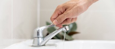 Su tasarrufu. Adam çevreyi korumak için tuvaletteki suyu kapatıp duruyor. Yeşillenen gezegen, küresel ısınmayı azalt Dünya 'yı, yaşamı, geleceği, risk enerjisini, krizi, su gününü kurtar.