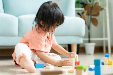 Mutlu Asyalı çocuk oyun oynuyor ve oyuncak bloklarını öğreniyor. Çocuklar evde çok mutlu ve heyecanlı. Çocuk oyun, etkinlik, gelişme ve dikkat eksikliği hiperaktivite bozukluğuyla çok iyi vakit geçiriyor