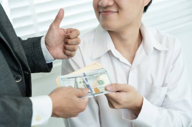 Businessmen receive salary or bonuses from management or Boss. Company give rewards to encourage work. Smiling businessman enjoying a reward at the desk in the office.