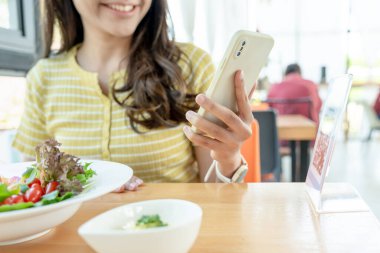 Woman use smartphone to scan QR code to pay in cafe restaurant with a digital payment without cash. Choose menu and order accumulate discount. E wallet, technology, pay online, credit card, bank app.