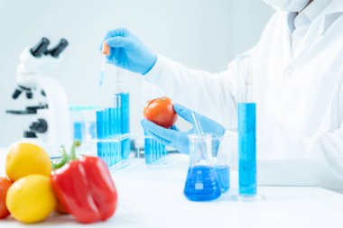 Bilimadamı laboratuvardaki kimyasal gıda kalıntılarını kontrol ediyor. Denetim uzmanları sebzelerin kalitesini inceler. Laboratuvar, tehlikeli maddeler, yasaklı maddeler, kirlilik, mikroskop, mikrobiyolog