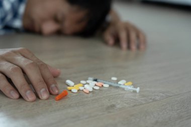 Asyalı erkek aşırı dozda hap kullanıyor, stresli, üzgün, uyuşturucu bağımlısı, uyuşturucu bağımlısı, hasta, sağlıksız, mutsuz, intihar, depresyonda veya umutsuz, uyuşturucu bağımlısı, yaşam ve aile sorunları, motivasyonsuz