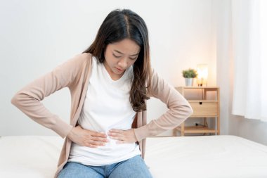 stomach ache. Asian women have abdominal pain, indigestion, gastritis, menstrual cramps, flatulence, diarrhea, distention, colon cancer, belly inflammation problem, suffer food poisoning, abdomen