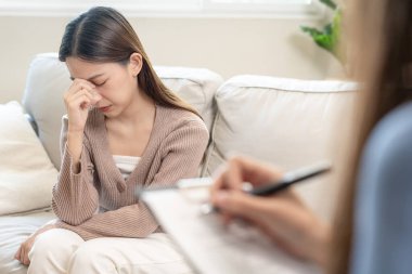 Akıl sağlığı sorunları olan bir kadın danışmanlık yapıyor. Psikiyatrist tedavi için hastanın durumunu kaydediyor. teşvik, sevgi ve aile sorunu, bipolar, depresyon hastası, intiharı koru