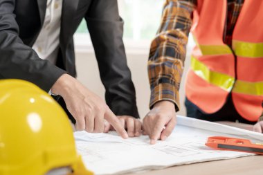 Mühendisler ve sahipleri inşaat planlarını gözden geçirip kontrol etmeyi tartıştılar. Sivil projeye başlamadan önce müteahhit teftişi çizimi. proje planlaması, danışmanlık, mimari