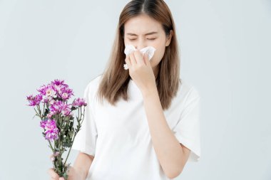 Polen alerjisi, mendile hapşıran Asyalı genç bir kadın veya mendile üfleyerek bahar çiçeklerine ya da bahar çiçeklerine alerjisi olan bir kadın. alerjik reaksiyon, solunum sistemi sorunları