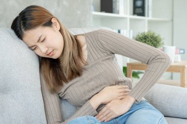 stomach ache. Asian women have abdominal pain, indigestion, gastritis, menstrual cramps, flatulence, diarrhea, distention, colon cancer, belly inflammation problem, suffer food poisoning, abdomen