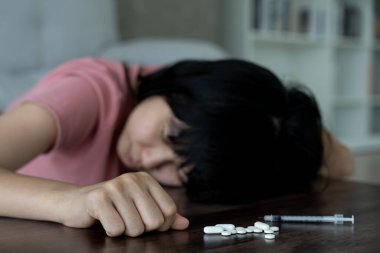 Asyalı kadın aşırı dozda hap kullanıyor, stresli, üzgün, uyuşturucu bağımlısı, hasta, sağlıksız, mutsuz, intihar, depresyon veya ümitsiz, uyuşturucu bağımlısı, yaşam ve aile sorunları, motivasyonsuz