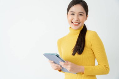 Asyalı güzel bir kız portresi ve izole edilmiş boş bir alan. İş kadını. Genç bir kadın işaret ediyor, reklam panosu, giriş, reklam, boşluk