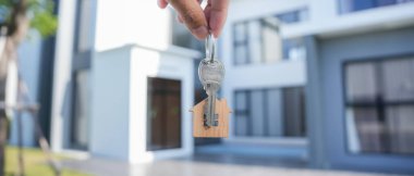 Kira, kiralama ve ev satma. Emlakçının elinde yeni sahibinin anahtarı var. kira, satış, kredi finans, sigorta, satıcı, dağıtıcı, taksit, satın alma, satma, taşınma