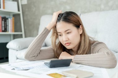 Yüklü faturaları ve faturaları olan stresli ve baş ağrısı çeken Asyalı kadın harcamaları ve kredi kartı borçlarını ödeyecek parası yok. kıtlık, mali sorunlar, mortgage, kredi, iflas, iflas, yoksul, boş cüzdan