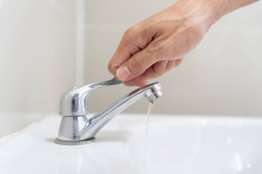 Save water. Volunteer keeps turning off the running water in the bathroom to protect environment. Greening planet, reduce global warming, Save world, life, future, risk energy, crisis , water day.