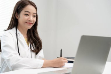 Telemedikal. Doktorlar, hastaların bir röportaj videosunun kaydını tutarlar. Asyalı doktor hastaları telekomünikasyon yoluyla tedavi ederken hastalığı tarif ediyor. Sağlık teknolojisi.