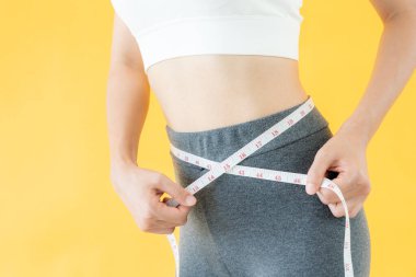 Diyet ve diyet. Güzel, ince kadın vücut ölçüsü. Spor elbiseli bir kadın sağlıklı yaşam için kilo verme hedefine, zayıflığa, ince belliye, beslenme uzmanına ulaşır..