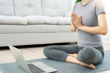 Kadın apartman dairesinde meditasyon yapıyor. Asyalı kadın sabah egzersiz yapıyor. denge, dinlenme, rahatlama, sakinlik, sağlık, mutluluk, rahatlama, sağlıklı yaşam tarzı, stresi azaltma, huzur, tutum.