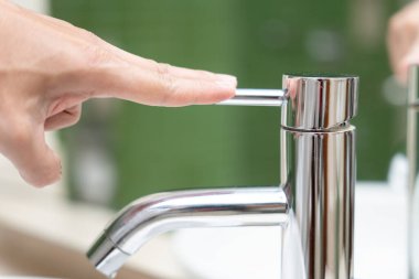 Su tasarrufu. Adam çevreyi korumak için tuvaletteki suyu kapatıp duruyor. Yeşillenen gezegen, küresel ısınmayı azalt Dünya 'yı, yaşamı, geleceği, risk enerjisini, krizi, su gününü kurtar.