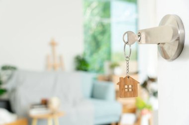 Taşınmak, taşınmak. Anahtar yeni evin kapısına yerleştirilmiş, odanın içinde kişisel eşyalar ve mobilyalar içeren bir karton kutu vardı. Daireye gir, afiş.