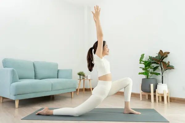 Slim woman practicing yoga on room of her condo or home. Asian woman doing exercises in morning. balance, meditation, relaxation, calm, good health, happy, relax, healthy lifestyle, diet, slim