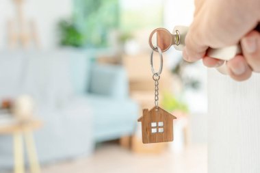 Taşınmak, taşınmak. Anahtar yeni evin kapısına yerleştirilmiş, odanın içinde kişisel eşyalar ve mobilyalar içeren bir karton kutu vardı. Daireye gir, afiş.