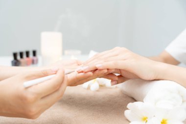 Kadın, güzellik merkezinde profesyonel güzellik manikürü ile bakım hizmeti alıyor. Güzellik salonunda jöle tedavisi için tırnak törpüsü kullanın. Manikürcü, çivi müşterisini güzelleştirir. vücut bakımı spa tedavisi