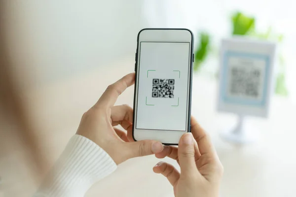 Modern woman use phone to scan barcode or QR codes to pay credit card bill after receive document invoice. payment, receive, paying electricity, digital payments without money, technology, scanning