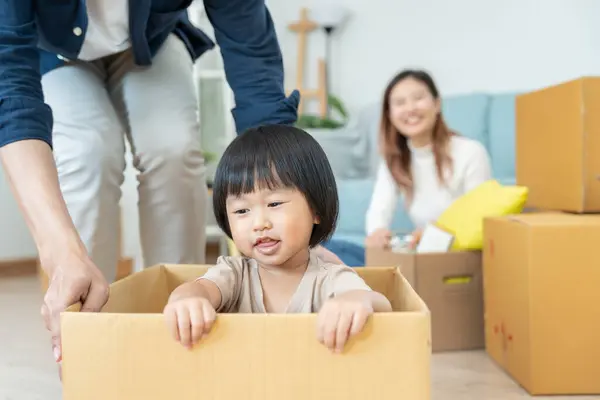 Moving house, relocation. Family smile and happy after buy new apartment, inside the room was a cardboard box contain personal belongings and furniture. move in the new apartment or condominium