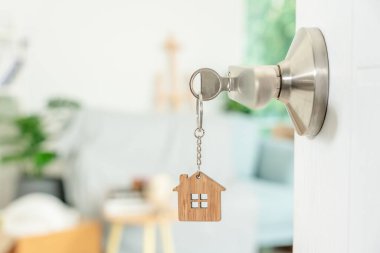 Moving house, relocation. The key was inserted into the door of the new house, inside the room was a cardboard box containing personal belongings and furniture. move in the apartment or condominium