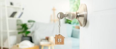 Moving house, relocation. The key was inserted into the door of the new house, inside the room was a cardboard box containing personal belongings and furniture. move in the apartment or condominium