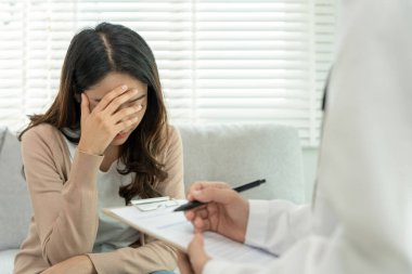 Akıl sağlığı sorunları olan bir kadın danışmanlık yapıyor. Psikiyatrist tedavi için hastanın durumunu kaydediyor. teşvik, sevgi ve aile sorunu, bipolar, depresyon hastası, intiharı koru