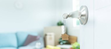 Moving house, relocation. The key was inserted into the door of the new house, inside the room was a cardboard box containing personal belongings and furniture. move in the apartment or condominiu