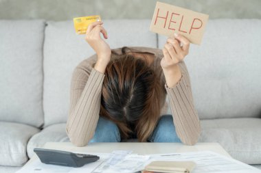 Yüklü faturaları ve faturaları olan stresli ve baş ağrısı olan bir kadın masrafları ve kredi kartı borçlarını ödeyecek parası yok. kıtlık, mali sorun, iflas, mortgage, kredi, iflas, yoksul, boş cüzdan 
