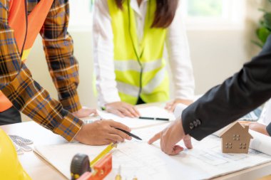 Mühendisler ya da müfettişler inşaat planlarını ellerinde tutuyorlar. Sivil projeye başlamadan önce müteahhit teftişi çizimi. İnşaat projesi planlama, danışmanlık ve mimariyi hazırlayın..