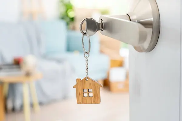 Moving house, relocation. The key was inserted into the door of the new house, inside the room was a cardboard box containing personal belongings and furniture. move in the apartment or condominiu