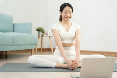 Evde ya da apartmanda yoga yapan zayıf bir kadın. Sabahları egzersiz yapan Asyalı bir kadın. denge, meditasyon, rahatlama, sakinlik, sağlık, mutluluk, rahatlama, sağlıklı yaşam tarzı, diyet, sli