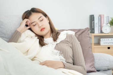 sick woman with a headache sitting under blanket, female sneezing and runny nose with seasonal influenza, allergic, high fever and influenza, resting, virus, coronavirus, feel illness, respiratory