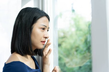 Depresyon ve akıl hastalığı. Asyalı kadın kötü haber aldıktan sonra hayal kırıklığına uğradı, üzüldü. Stresli kız mutsuz problemlerle kafası karışık, erkek arkadaşıyla tartışıyor, ağlıyor ve beklenmedik hamilelik için endişeleniyor..