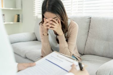 Akıl sağlığı sorunları olan bir kadın danışmanlık yapıyor. Psikiyatrist tedavi için hastanın durumunu kaydediyor. teşvik, sevgi ve aile sorunu, bipolar, depresyon hastası, intiharı koru