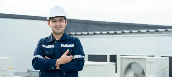 Portrait Asian maintenance engineer works on the roof of factory. contractor inspect compressor system and plans installation of air condition systems in construction, inspector, control