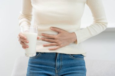 Süt alerjisi, hasta, üzgün, sağlıksız, kadının kafası karışık süt içen, burnu akan, dayanıksızlığa karşı alerjisi olan, alerji belirtilerinden muzdarip. karın ağrısı, alerji, protein, döküntü, ölüm, gıda alerjisi