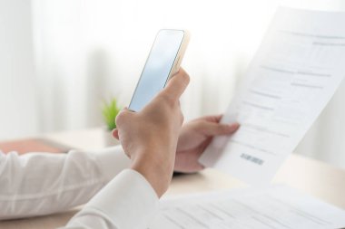 business man use phone to scan barcode or QR codes to pay credit card bill after receiving document invoice online. payment, receive, paying electricity, digital payments without money, technology
