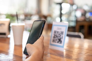 Adam akıllı telefonu, kafeteryada nakit olmadan dijital ödeme yapmak için QR kodunu taramak için kullanıyor. Menüyü ve siparişi seçin ve indirimi toplayın. E cüzdan, teknoloji, online ödeme, kredi kartı, banka uygulaması.