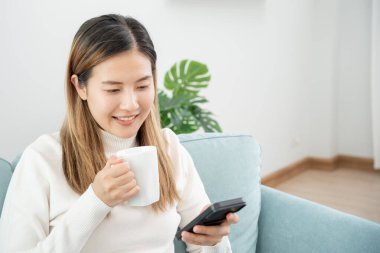Evde online alışveriş için akıllı telefon kullanan bir kadın. evde kalmak, teknoloji, elektronik ticaret, internet, pazar yeri, final veya yaz ya da büyük satış, ödeme, kredi indirimi, teklif, düşük fiyat