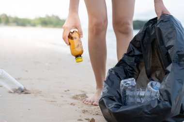 Okyanusu kurtar. Gönüllü olarak plajdaki çöpleri topluyor ve plastik şişeler suda yaşayan canlılara zarar gelmesini engelliyor. Dünya, Çevre, Yeşilci Gezegen, küresel ısınmayı azaltmak, Dünya 'yı kurtarmak