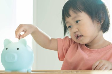 Para biriktir. Çocuklar biriktirmek için para koyuyorlar. wealth, Finans, Sigorta, Yatırım, Eğitim, Gelecek, Planlama Hayatı, Öğrenme, Bankacılık, Aile, Sağlık, Sağlık ve Kaza Sigortası