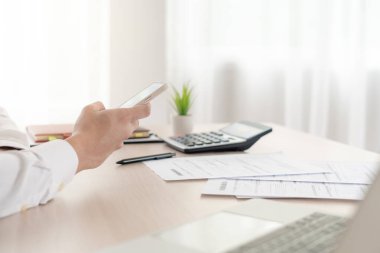 business man use phone to scan barcode or QR codes to pay credit card bill after receiving document invoice online. payment, receive, paying electricity, digital payments without money, technology